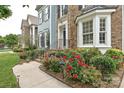 Exterior view of a house featuring a brick facade, blue siding, lush landscaping, and a sidewalk leading to the entrance at 11232 Tradition View Dr, Charlotte, NC 28269