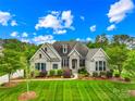 Beautiful single-Gathering home with a manicured lawn and an elegant brick and stone facade at 1128 Rosecliff Dr, Marvin, NC 28173