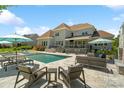 Inviting backyard featuring a swimming pool, lounge chairs, and a patio with comfortable seating and outdoor lighting at 1149 Grand Oak Dr, Waxhaw, NC 28173