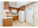 Kitchen with wood cabinets, white appliances, and an adjacent door to the exterior at 1214 Short St, Salisbury, NC 28144
