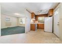 Eat-in kitchen featuring wood cabinets, white appliances, linoleum floors, and natural light from the adjacent room at 1214 Short St, Salisbury, NC 28144