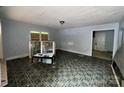 Spacious living room featuring vintage flooring, a light fixture, and ample natural light from the windows at 1224 Bailey St, Albemarle, NC 28001