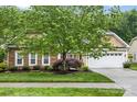 Attractive home showcasing stone accents, a well-maintained lawn, and a two-car garage, enhancing its visual appeal at 1244 Saint Johns Ave, Matthews, NC 28104