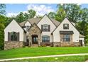 A stylish home featuring a meticulously landscaped lawn and a stone and neutral stucco exterior at 13106 Bien Ct, Huntersville, NC 28078