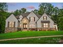 Beautifully landscaped home featuring a stone and neutral stucco exterior with a manicured lawn at 13106 Bien Ct, Huntersville, NC 28078