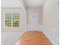 Welcoming foyer with hardwood floors, decorative molding, and natural light from a large window at 15009 Medlock Ln, Charlotte, NC 28277