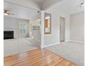 Bright living room featuring a fireplace, neutral carpet, and hardwood entry at 15009 Medlock Ln, Charlotte, NC 28277