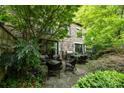 A private outdoor patio with stone flooring, surrounded by lush greenery, and cozy seating arrangements at 1550 High St, Charlotte, NC 28211