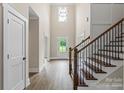 Bright foyer featuring hardwood floors, a staircase with wrought iron railings, and a high ceiling with a modern chandelier at 156 Clear Springs Rd, Mooresville, NC 28115