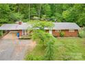 An aerial view of a well-kept brick house with a covered carport and mature trees at 1713 Wildwood Dr, Albemarle, NC 28001