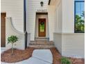 Elegant home entrance featuring brick steps, a wood door with a wreath, and manicured landscaping at 1807 Arnold Dr, Charlotte, NC 28205