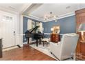 Elegant living room with hardwood floors, a grand piano, and stylish decor with blue accent wall at 209 Helton Ln, Fort Mill, SC 29708