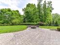 Manicured backyard featuring a stone fire pit, landscaping, and plenty of green space at 2369 Baxter Se Pl, Concord, NC 28025