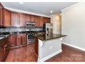 Modern kitchen featuring stainless steel appliances, granite countertops, and beautiful dark wood cabinetry at 2369 Baxter Se Pl, Concord, NC 28025