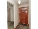 Front entryway featuring a beautiful solid wood door with decorative design elements and carpet floor at 2412 Wedgewood Dr, Salisbury, NC 28146
