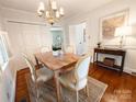 Cozy dining area with hardwood floors, a chandelier, and natural light from a nearby window at 3020 Hampton Ave, Charlotte, NC 28207