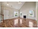 Bright living room features a fireplace, hardwood floors, and large windows at 3038 Twin Peaks Ct, Monroe, NC 28110