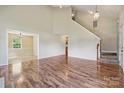 Spacious living room with hardwood floors, tall ceilings, and staircase access at 3038 Twin Peaks Ct, Monroe, NC 28110