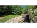 Beautiful backyard featuring a decorative rock bed, mature trees and lush landscaping at 307 Aquarius Dr, Clover, SC 29710
