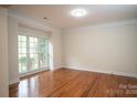 Well-lit bedroom featuring hardwood floors, crown molding, and a large window overlooking the yard at 4410 Laurel Twig Ct, Charlotte, NC 28215