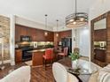 Charming kitchen with wood cabinets, a central island with seating, and a dining nook with a glass table, ideal for cozy meals at 4625 Piedmont Row Dr # 701, Charlotte, NC 28210