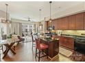 Stylish kitchen open to the living area with dark wood cabinets, stainless steel appliances, and a center island with bar stool seating at 4625 Piedmont Row Dr # 701, Charlotte, NC 28210