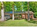 A lovely single-story brick home featuring a durable metal roof and surrounded by lush greenery and mature trees at 612 Summerow Rd # Lot 22, Stanley, NC 28164