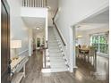 Bright foyer with staircase, wood floors, and views into dining and living areas at 6723 Joliette Ln, Charlotte, NC 28277