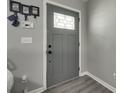 Modern entryway featuring gray walls, light-colored wood floors, and a stylish gray door with decorative glass at 735 Shuttles Way, Fort Mill, SC 29715