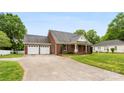 View of the brick home with an attached two-car garage and a long driveway at 102 Sussex Ave, Cherryville, NC 28021