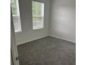 Empty bedroom featuring gray carpet and two windows at 113 Stoney Ln, Cherryville, NC 28021