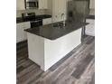Kitchen island with granite countertop, stainless appliances, white cabinets and gray wood-look flooring at 113 Stoney Ln, Cherryville, NC 28021