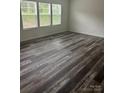 Light filled living room with three windows and new gray wood-look flooring at 113 Stoney Ln, Cherryville, NC 28021
