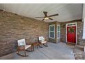 Inviting front porch with stone facade, rocking chairs, and ceiling fan; perfect for enjoying the outdoors at 11621 Mount Argus Dr, Cornelius, NC 28031