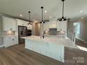 Bright kitchen featuring a center island, stainless steel appliances, white cabinets, and modern pendant lighting at 12033 Lavinia Ln, Charlotte, NC 28277