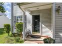 Close up of the front door with storm door, plants, and bushes at 1346 Mandy Place Ct, Charlotte, NC 28216