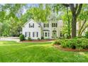 Charming two-story home with a well-manicured lawn, lush landscaping, and a welcoming green front door at 3134 Old Chapel Ln, Charlotte, NC 28210