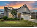 Charming home with a two-car garage, landscaping, and a colorful sunset at 3333 Oliver Stanley Trl, Lancaster, SC 29720