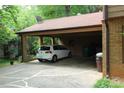Attached carport featuring a white vehicle and ample storage space at 425 Roselawn Pl, Charlotte, NC 28211