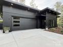 Modern home with a dark exterior, featuring a flat roof, and concrete driveway at 444 Starnes Circle Dr, Taylorsville, NC 28681