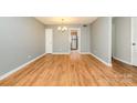 A view of a spacious living room featuring hardwood floors, neutral walls, and ample natural light at 4609 Coronado Dr # N, Charlotte, NC 28212