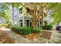 Exterior view of blue condo building showcasing mature landscaping, shade trees, and sidewalk at 611 Olmsted Park Pl # C, Charlotte, NC 28203