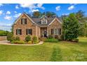 Charming brick home featuring a well-maintained lawn, manicured shrubbery, and an inviting front entrance at 7923 Mountain Shore Dr, Sherrills Ford, NC 28673