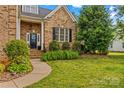 Beautiful home with a welcoming entrance, complemented by lush landscaping and a paved walkway at 7923 Mountain Shore Dr, Sherrills Ford, NC 28673