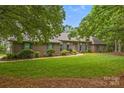 Attractive brick home with well-kept lawn, complemented by mature trees and lush landscaping at 8368 Fairfield Forest Rd, Denver, NC 28037