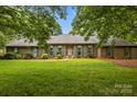 Inviting brick home with arched windows, green shutters, and a well-maintained lawn at 8368 Fairfield Forest Rd, Denver, NC 28037