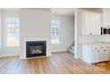 Bright living room with fireplace, wood floors, and lots of natural light from the many windows at 9612 Pointer Rd # 59, Huntersville, NC 28078