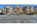 Exterior view of a multi-story condominium building with ample parking spaces at 104 Pier 33 Dr # 312, Mooresville, NC 28117