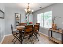 Charming dining room with rustic wood table, six chairs, and natural light from a window at 10408 Milstead Ct, Charlotte, NC 28215