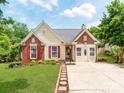 Inviting single-Gathering home with a brick and vinyl facade, red shutters, and a lush green lawn at 10408 Milstead Ct, Charlotte, NC 28215